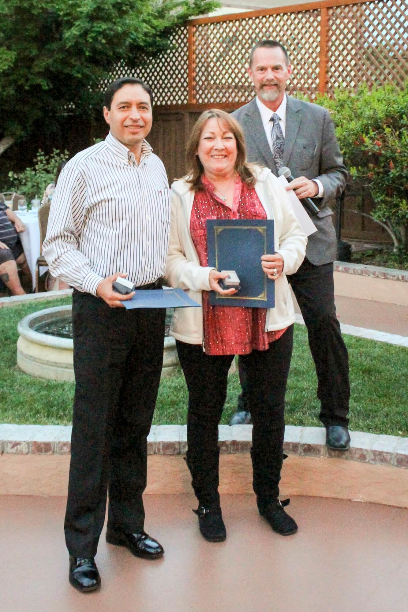 Dr. Kevin Flanigan presented 15-year pins of service to Oscar Morales and Linda Little.