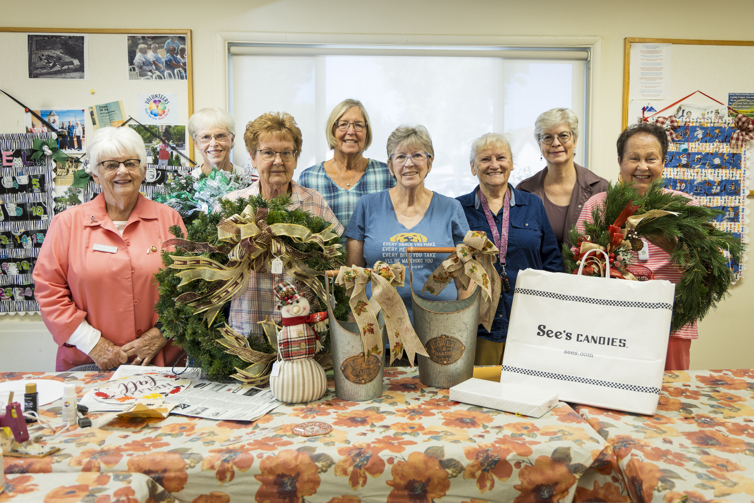 Eight members of the NIH Auxiliary show items handcrafted for their upcoming boutique including wreaths and cloth snowmen